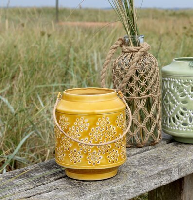 Foto: Gul emaljljuslykta på träbänk vid strandgräs