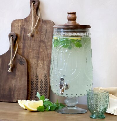 Bild av glasbehållare med kran och citrusdukning