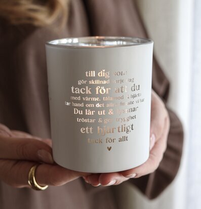 Foto: Ljuslykta i händer med tacksamhetstext, grå