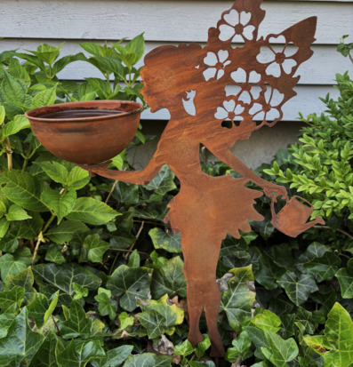 Foto: Rostig blomsterälva med fågelbad i grönska