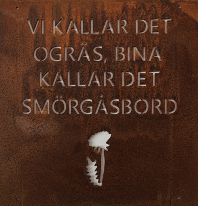 Bild på rostig skylt: Vi kallar det ogräs, bina...