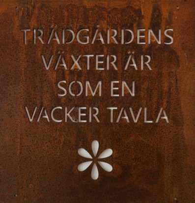 Foto: Rostig metallskylt med text om trädgårdens växter