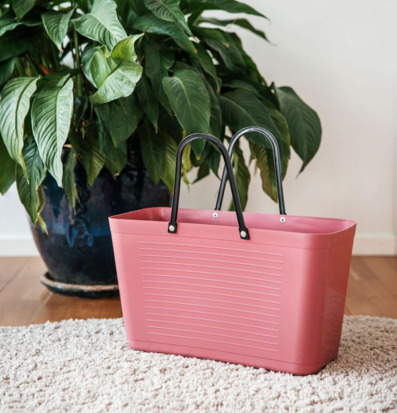 Foto: Varmrosa plastväska med svarta handtag hemma