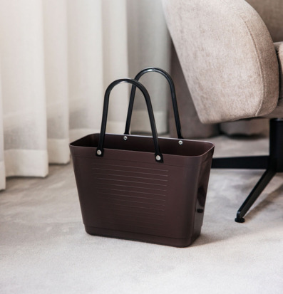 Foto brun plastbärkasse med svarta handtag i vardagsrum