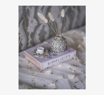 Foto: Stillben med boklåda, vas och ljushållare i tyg