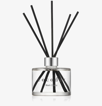 Foto doftspridare med svarta doftpinnar mot vitt bakgrund