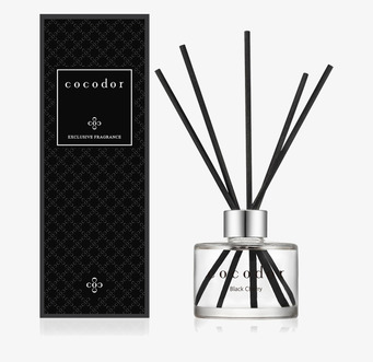 Foto doftspridare med pinnar och svart förpackning