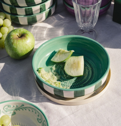 Foto: Keramisk rivskål med äpple och vindruvor i ljus