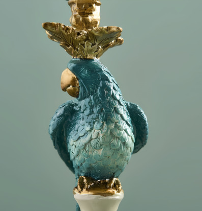 Foto: Turkos papegojljusstake med gulddetaljer i närbild