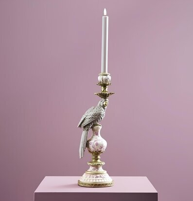 Foto av ljusstake med papegoja på rosa piedestal