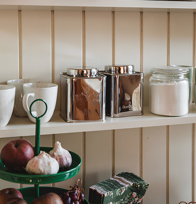 Foto: Stilren kökshylla med burkar, skålar och frukt