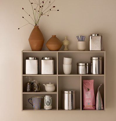 Bild på kökshylla med plåtburkar och keramikstilleben