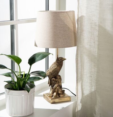 Bild: Bordslampa med fågelfot i ljus fönsternisch