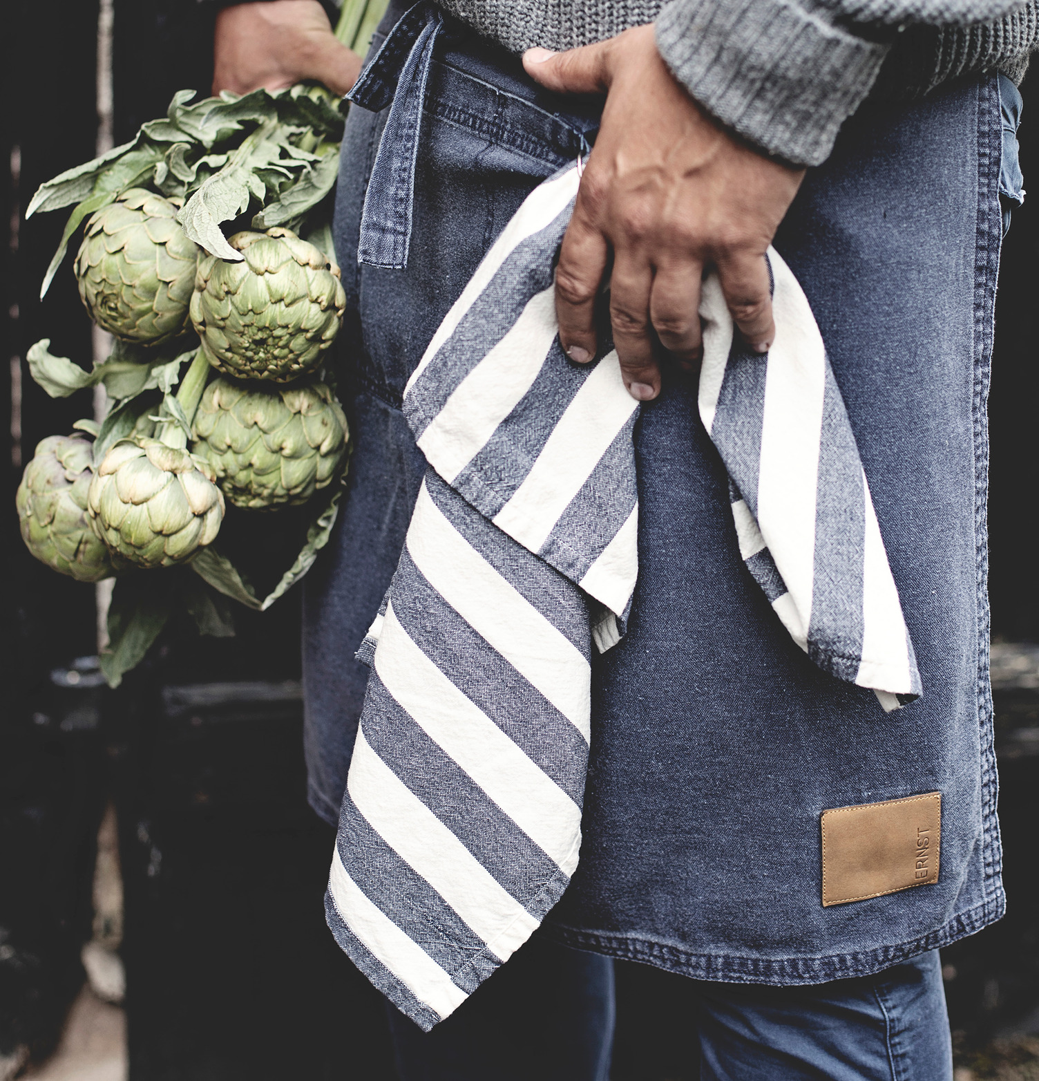 Person håller i Kökshandduk Randig Blå från Ernst utomhus