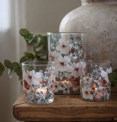 Foto: Tända glaslyktor med blommönster och vas i ro￼