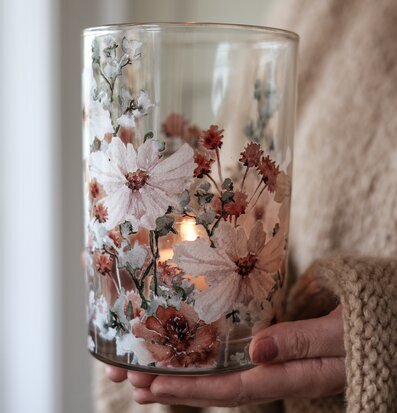 Foto: Glaslykta med blommönster och tänt värmeljus