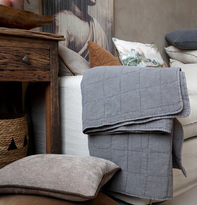 Foto: Sovrum med quilt, kuddar och rustikt träbord