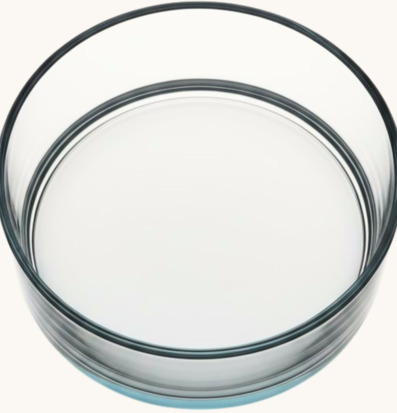 Foto av rund transparent glasskål på ljus bakgrund