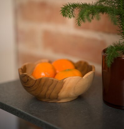 Foto: Träskål med apelsiner på grå bänk och tegelvägg