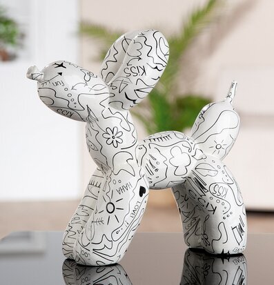 Foto: Vit ballonghund med line art-mönster på bord