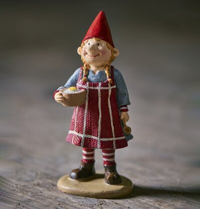 Foto på tomtefigur med gröt och röd luva i närbild