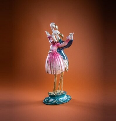 Foto: Flamingodans-figur i rosa/blått på brun bakgrund