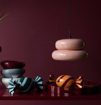Foto: Vinrött stilleben med karamellformer och lampa