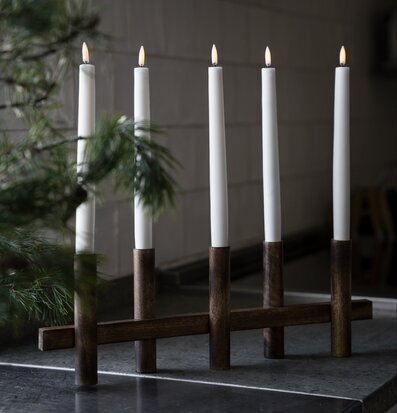 Bild på fem vita kronljus i mörk trästake i advent