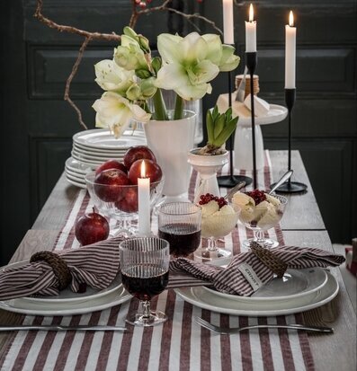 Foto: Dukat bord med rödvit randig löpare och ljus