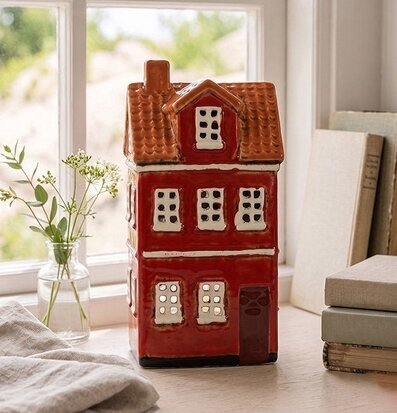 Foto: Röd ljuslykta som hus på ljus fönsterbänk