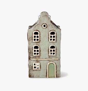 Foto på gråbeige ljuslykta hus med fönsterdetaljer