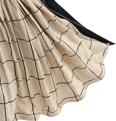 Foto: Beige rutig textil med svarta linjer, veckad 