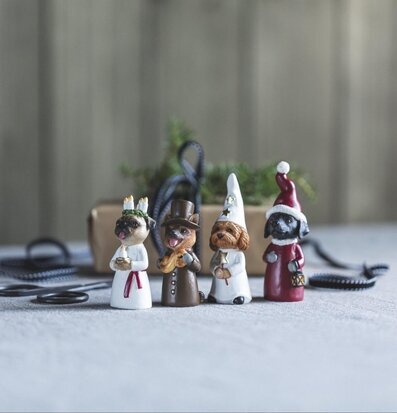 Foto av luciatåg med hundfigurer och julstilleben