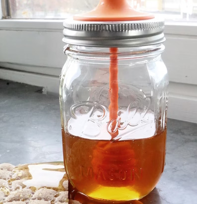 Honey Dipper från Ball Mason Jar med honung och knäckebröd