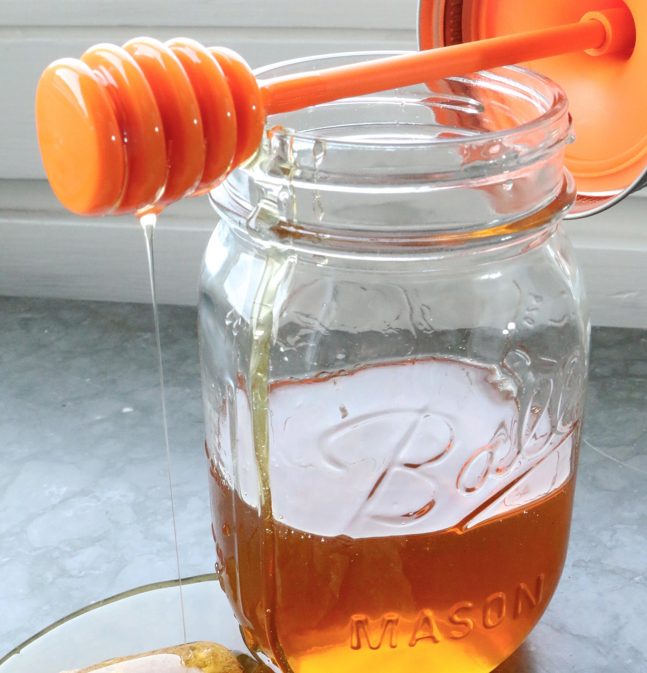 Honey Dipper och Ball Mason Jar med gyllene honung