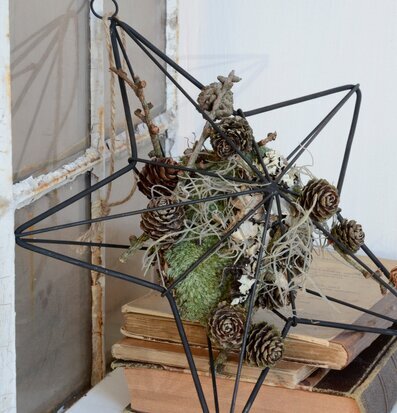 IB Laursen Stjärna 27 cm i svart metall på gamla böcker