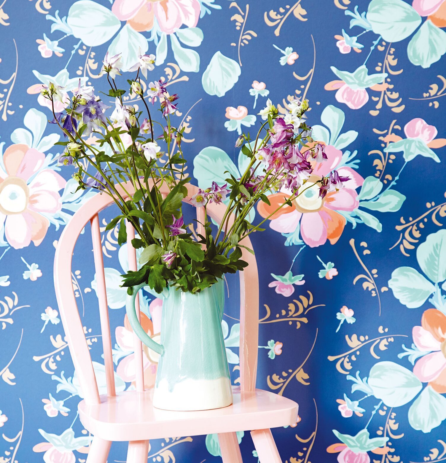 Tapet Rice från Rice med färgstarka blommor och pastellstol