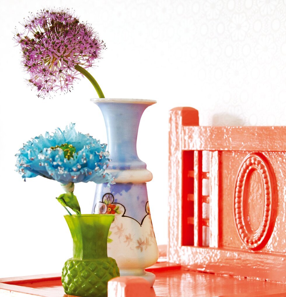 Tapet Rice från Rice med vaser på en korallröd möbel