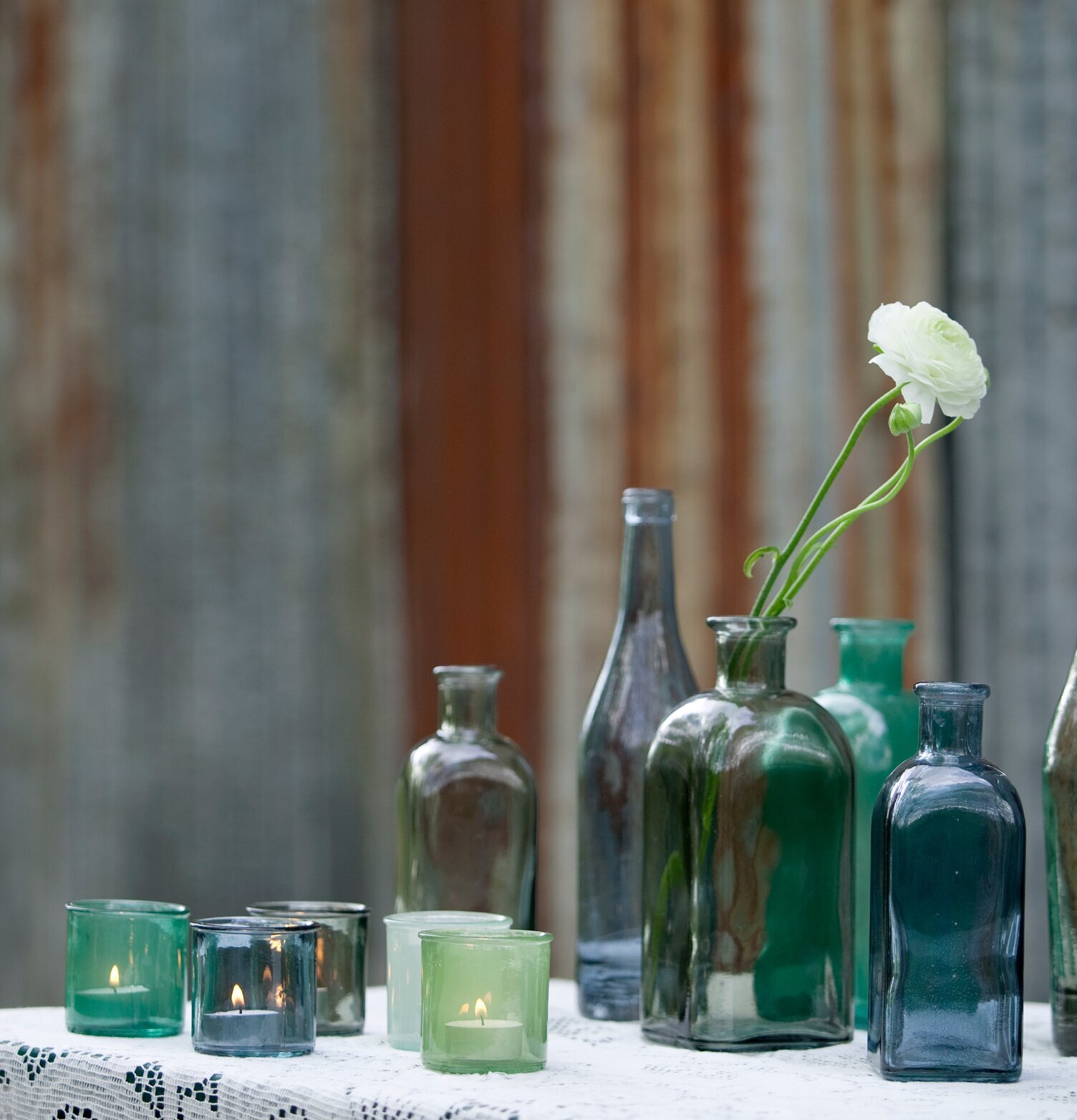 Bordsflaska Dimblå, 1L från Dixie omgiven av glasföremål