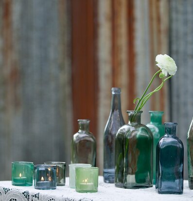 Bordsflaska Dimblå, 1L från Dixie omgiven av glasföremål