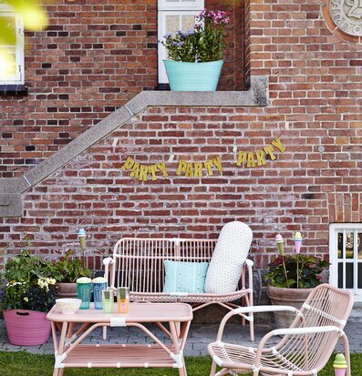 Cane 2 Seater Sofa Soft Coral från Rice i trädgårdsmiljö