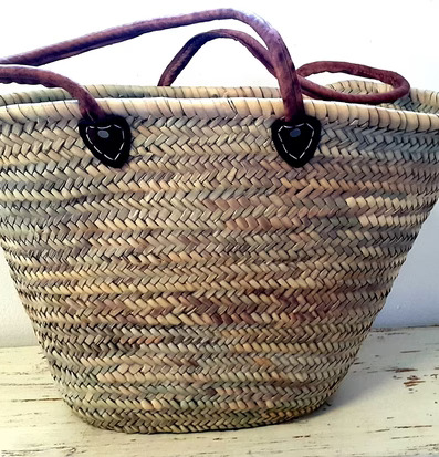 Stråväska från Nomadic Essentials på vitmålad trähylla