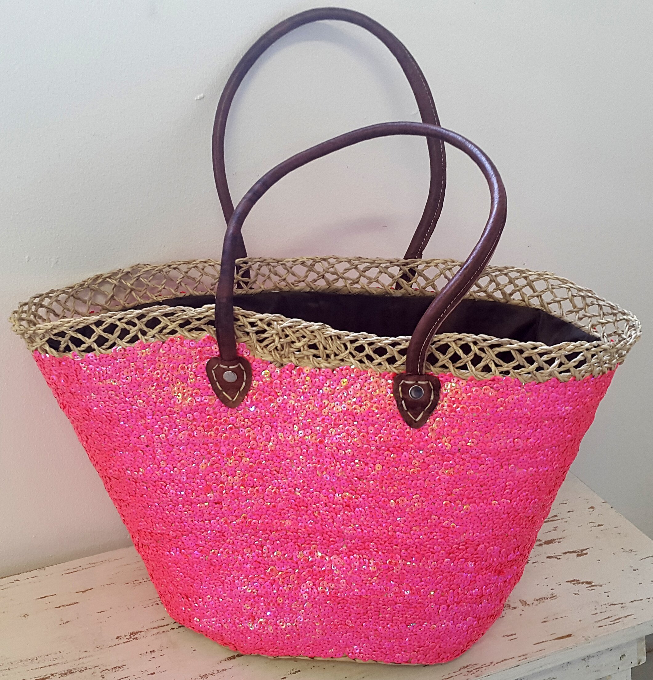 Stråväska DecoLux Cerise från Nomadic Essentials på träyta