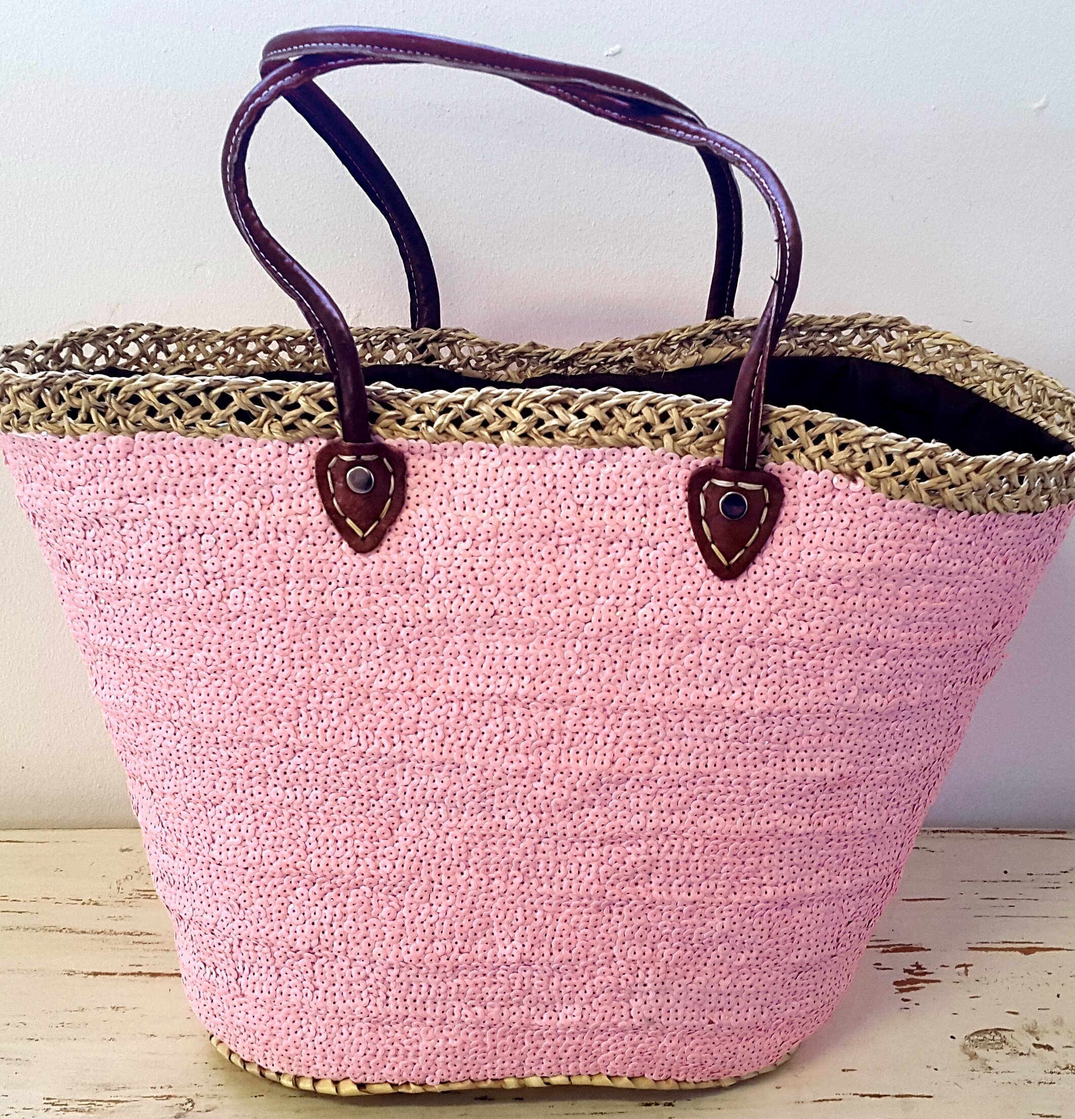 Stråväska DecoLux Pink från Nomadic Essentials på trägolv