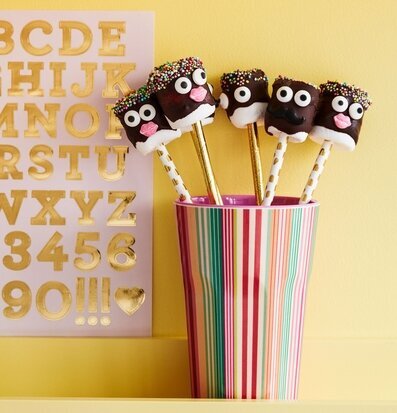 Bild av färgglada godsaker i mugg med randigt mönster