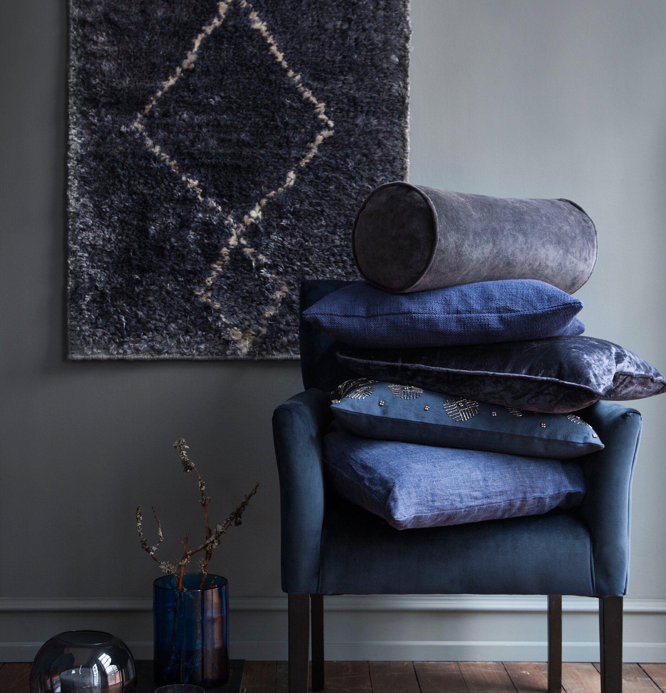 Bolsterkudde Sammet Cole från Cozy Living på blå fåtölj