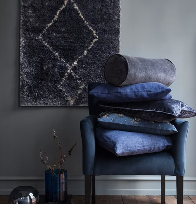 Bolsterkudde Sammet Cole från Cozy Living på blå fåtölj