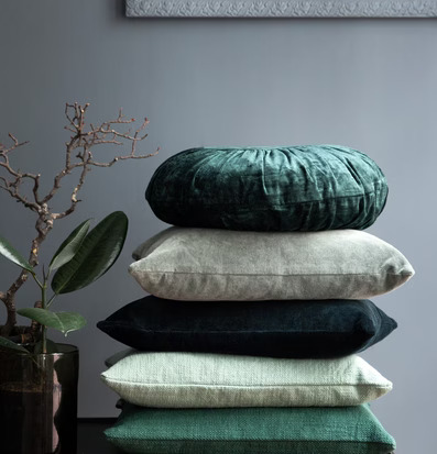 Sammetskudde Rund Dark Green från Cozy Living på mörkt bord