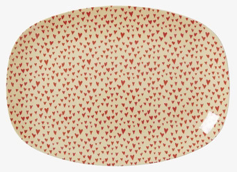 Liten Tallrik Hjärtan från Rice med röda hjärtan på ljus bakgrund