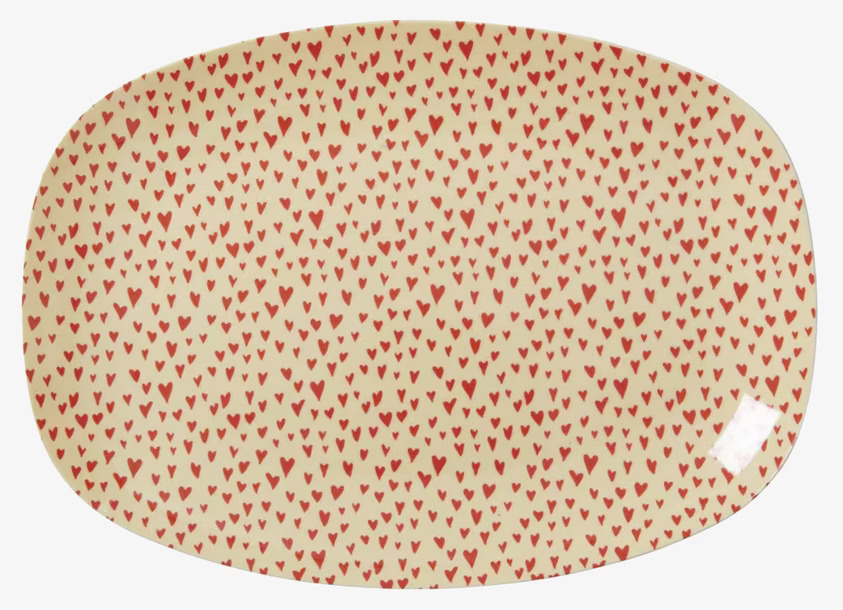 Liten Tallrik Hjärtan från Rice med röda hjärtan på ljus bakgrund